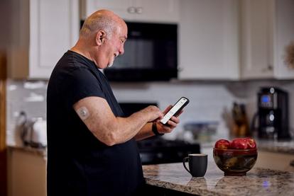 Dean on his phone in the kitchen