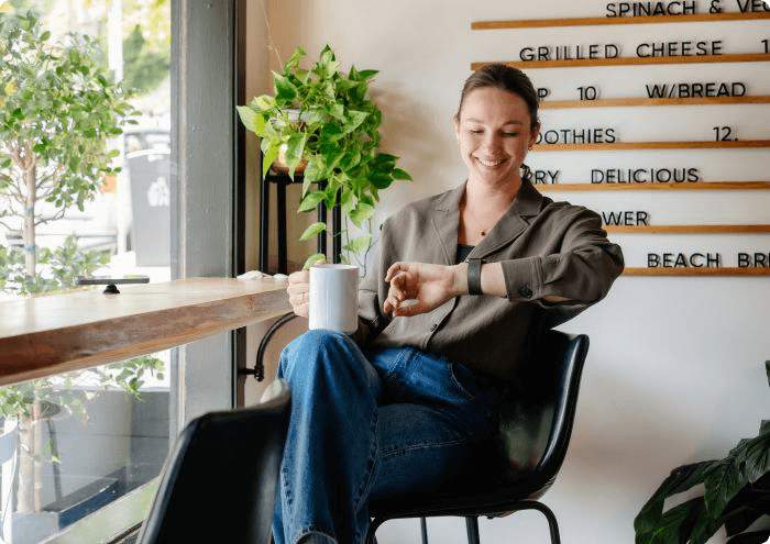 Charlotte drinking cup of coffee and checking her watch
