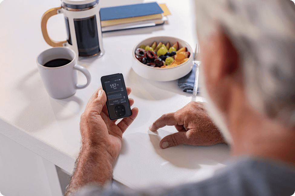 Man looking at his readings on his device while having breakfast