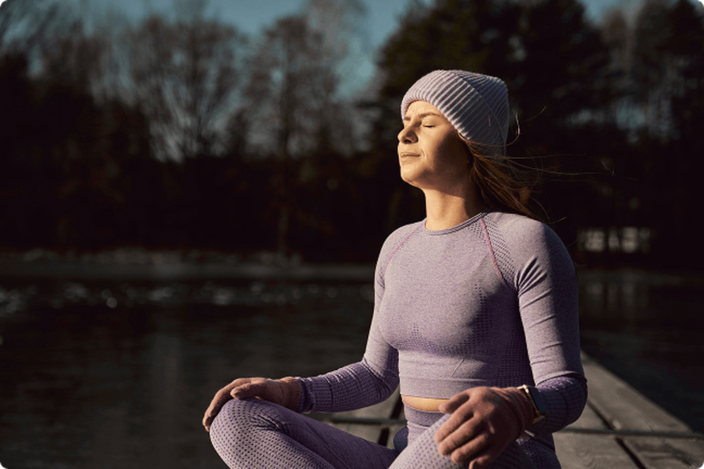 Woman sitting on a dock at sunrise