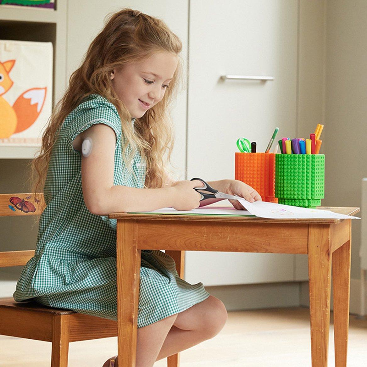 young girl doing homework wearing the D1+ sensor