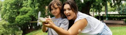 Woman and young boy flying a model airplane