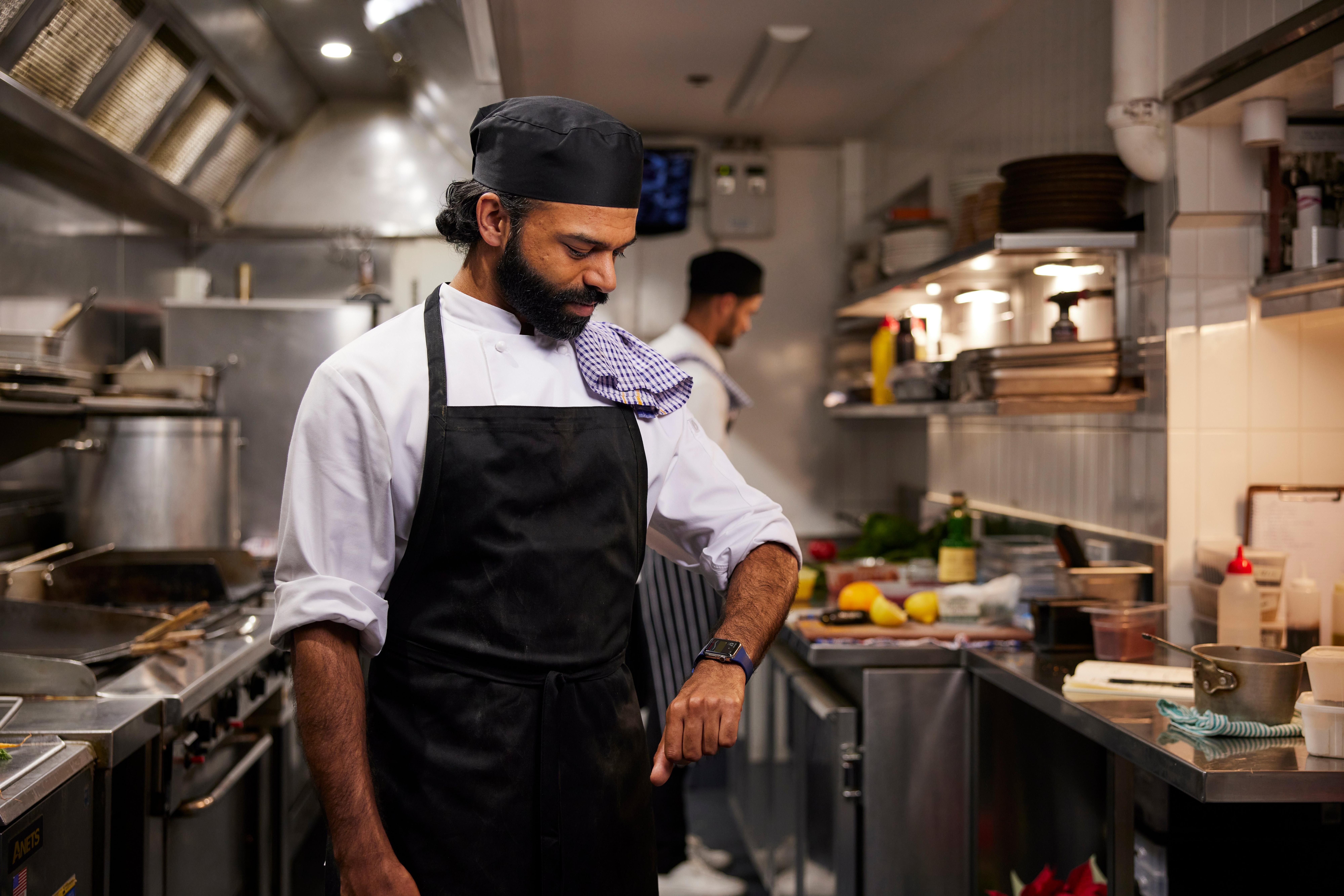 Man in kitchen looking at watch