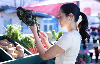 Woman looking at vegetables in an outside market