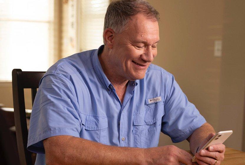 Dexcom Warrior Jimi Looking at phone and Smiling