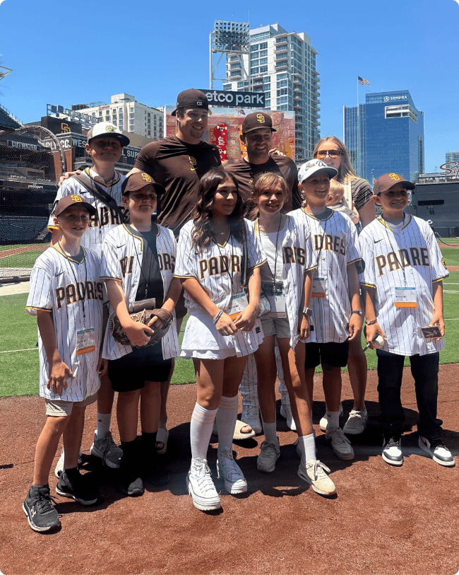 Mason taking a group picture with kids on a baseball field