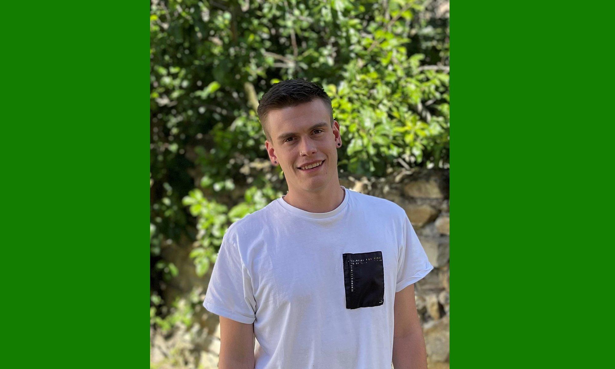 Young guy standing in front of a tree