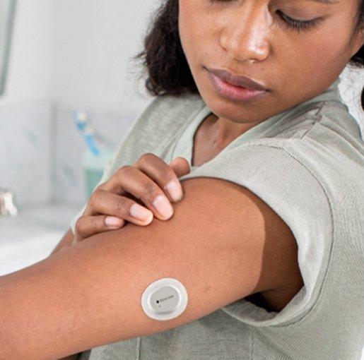 A Dexcom One+ sensor on the back of the arm
