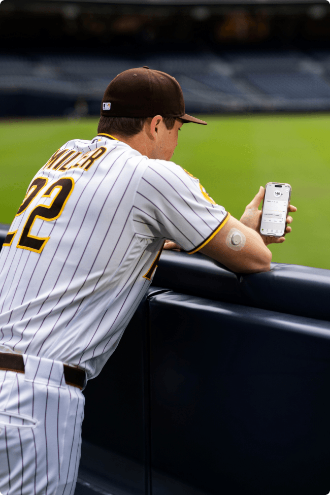 Mason wearing the Dexcom sensor in the bullpen looking at his phone readings