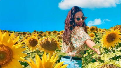 Glimlachende vrouw in een veld met zonnebloemen