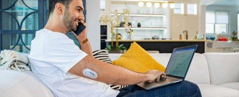 شخص لديه جهاز استشعار مرض السكري Dexcom G6 في الجزء العلوي من ذراعه