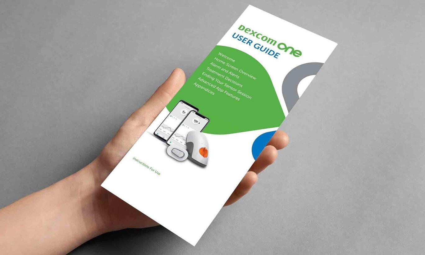Hand holding Dexcom one user guide
