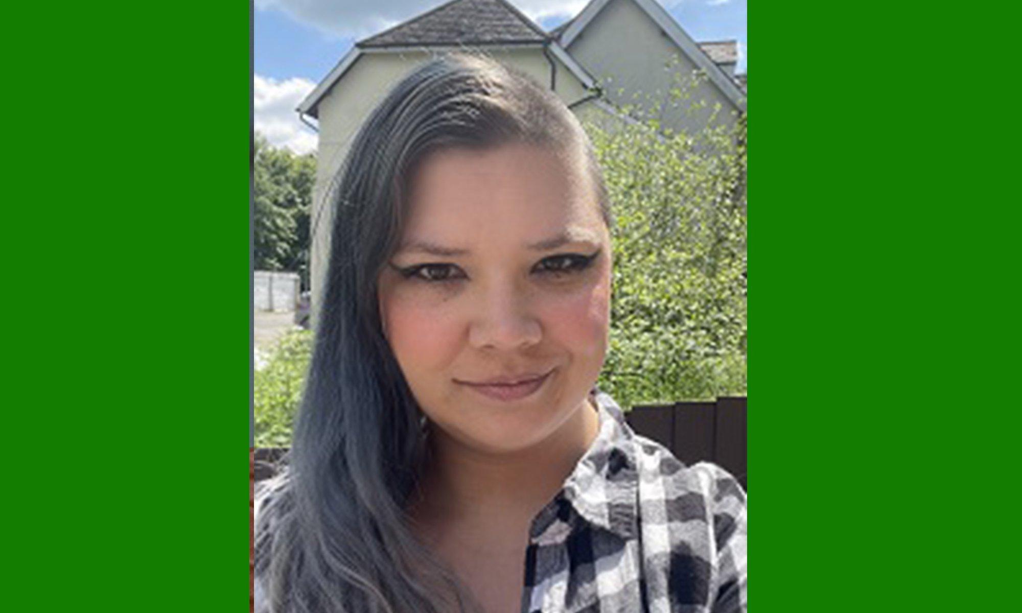 Girl looking directly in the camera in a sunny surrounding.