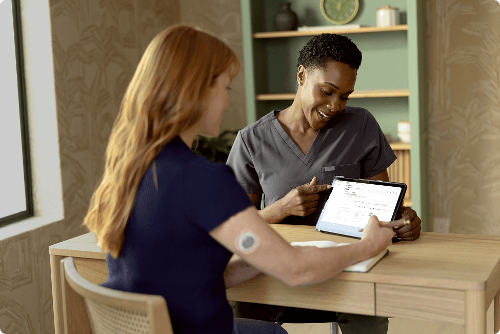 Woman wearing Stelo sensor looking at her medical information with her doctor