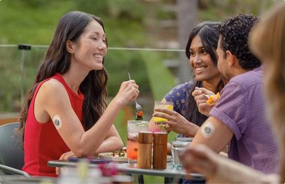 Woman and man wearing Stelo sensors out to eat with a friend