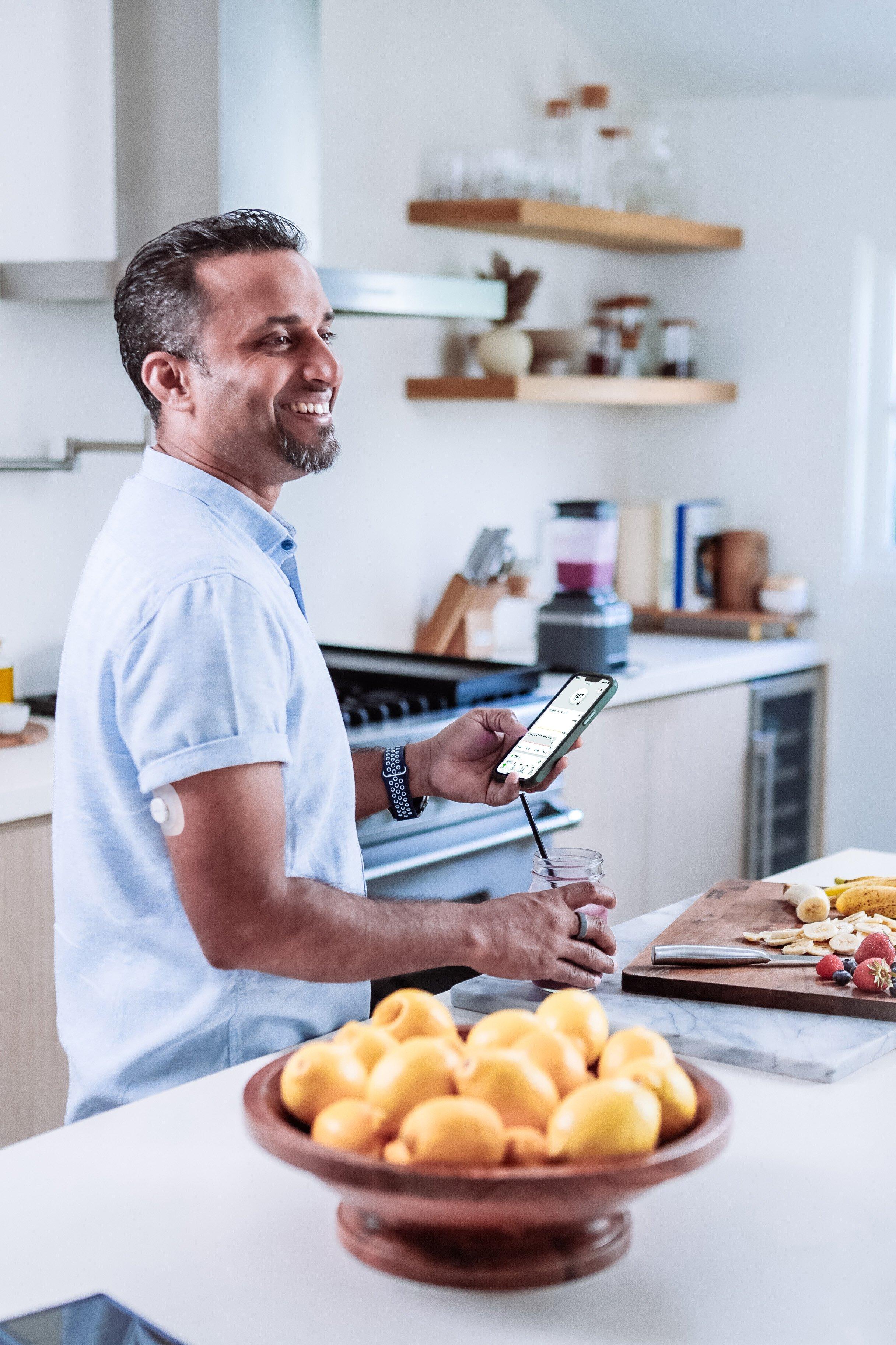 Dexcom warrior Jason making a smoothie while checking his glucose on the Dexcom G7 app