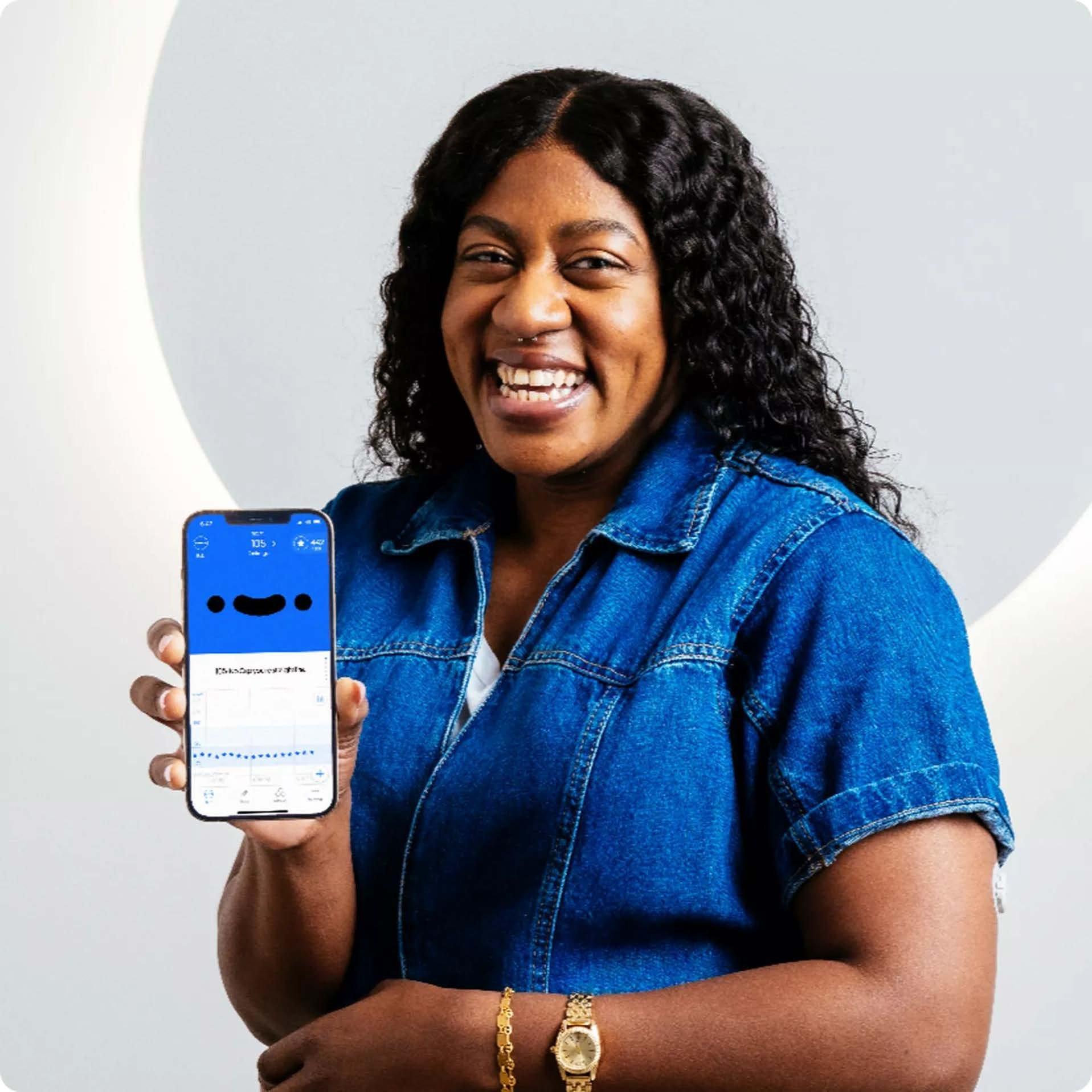 Woman smiling and holding phone showing Hello Bob app