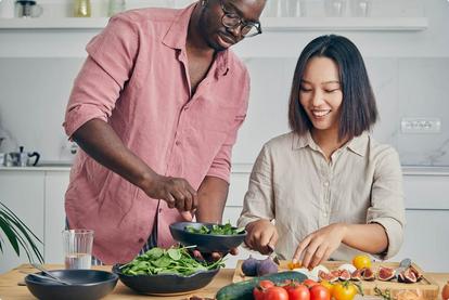 Man and woman in kitchen making a salad