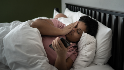 Woman lying in bed on phone