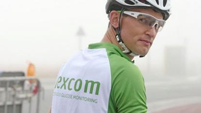 Dviratininkas su žaliai baltais "Dexcom" marškinėliais