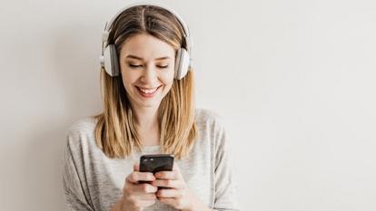 Woman Listening to Podcast smiling