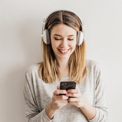 Woman Listening to Podcast smiling