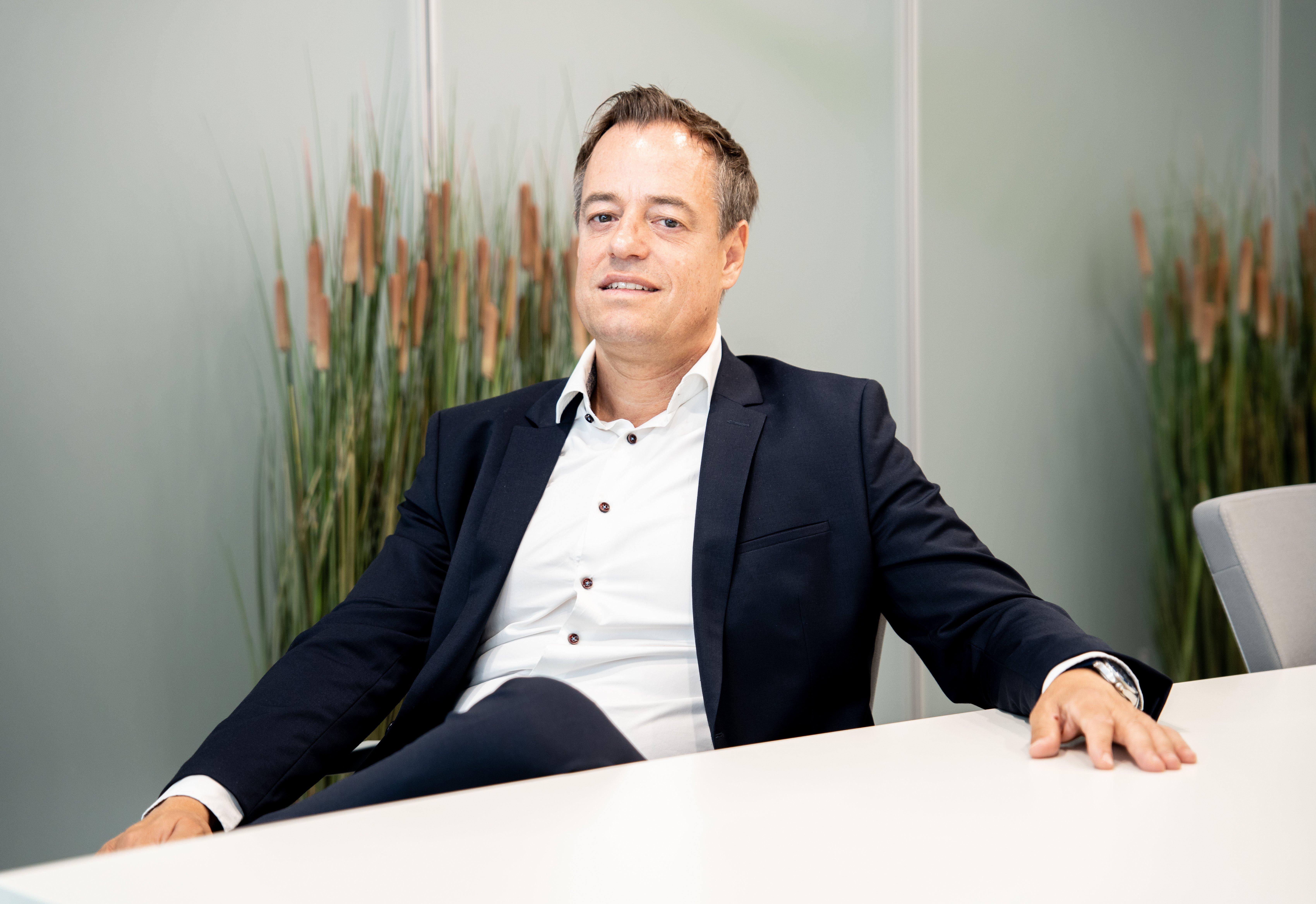 Managing Director Alexander Fröhlich for Dexcom Germany sitting down on a chair at a white table