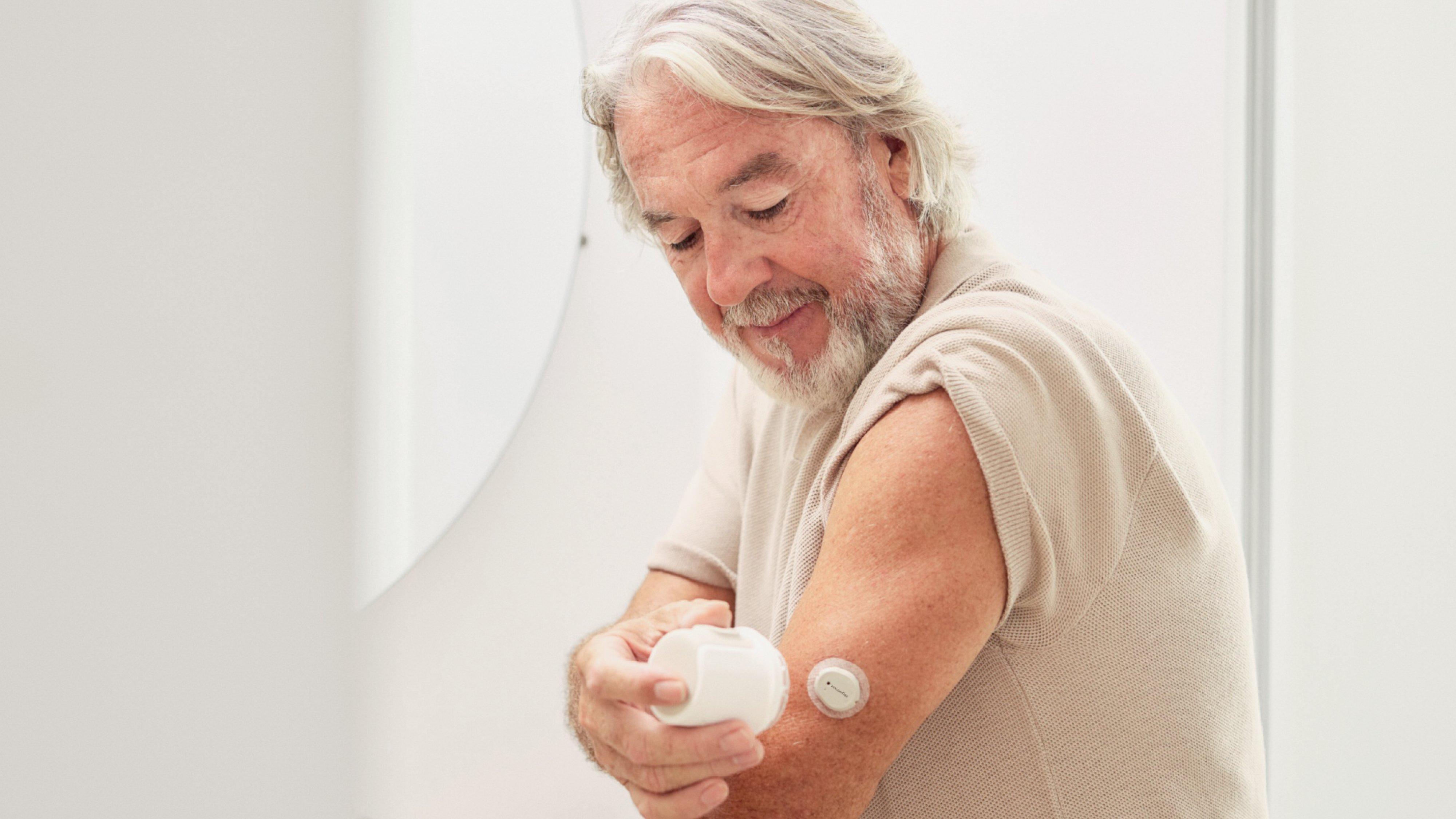 Eine Frau setzt sich den neuen Dexcom Flex Sensor für Typ-2-Diabetes an die Rückseite ihres Oberarms. 