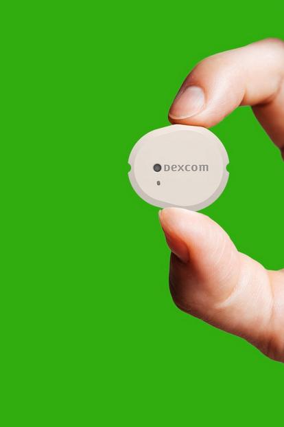 Mano che tiene il sensore Dexcom G7 su sfondo verde