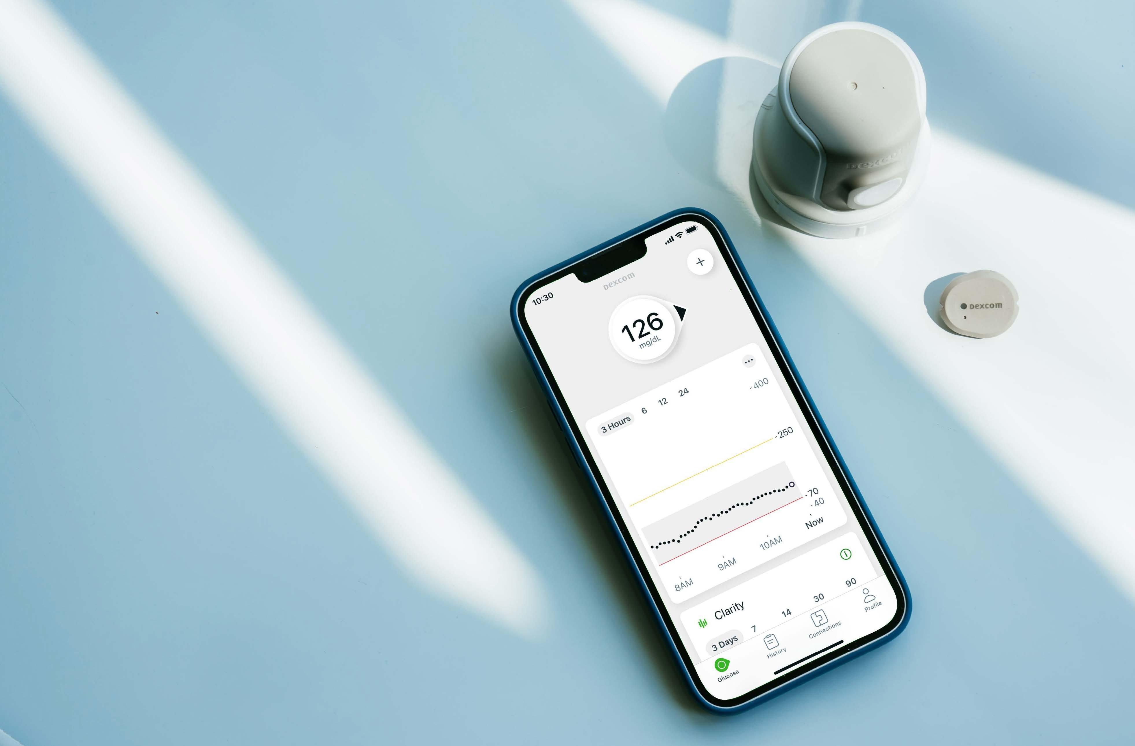Dexcom G7 sensor and smartphone showing G7 readings