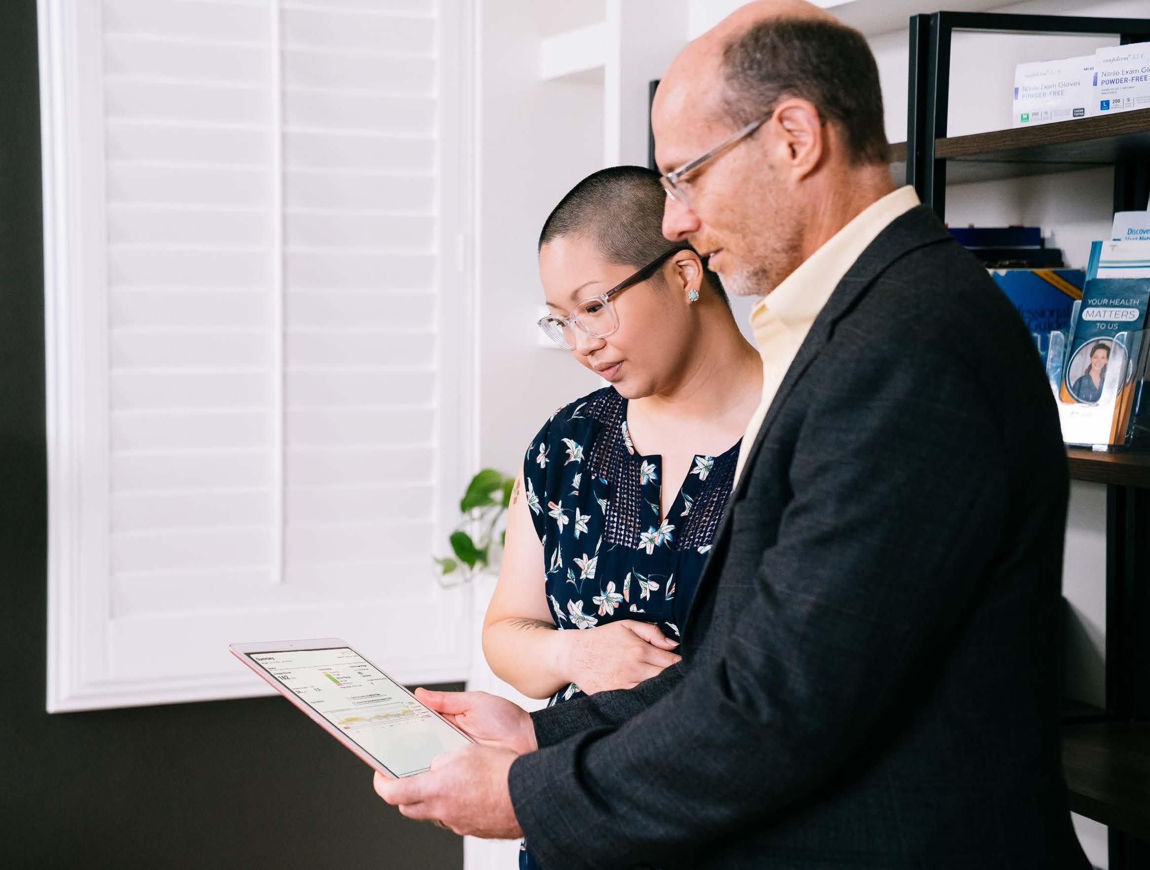Woman and Doctor reviewing glucose levels on the Dexcom CGM app