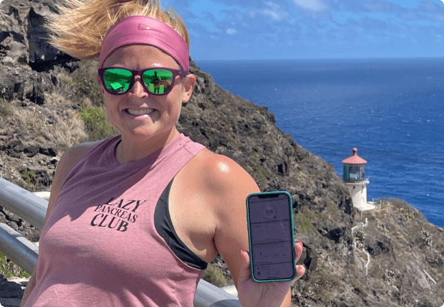 Davon on a mountain showing glucose reading on the Dexcom app
