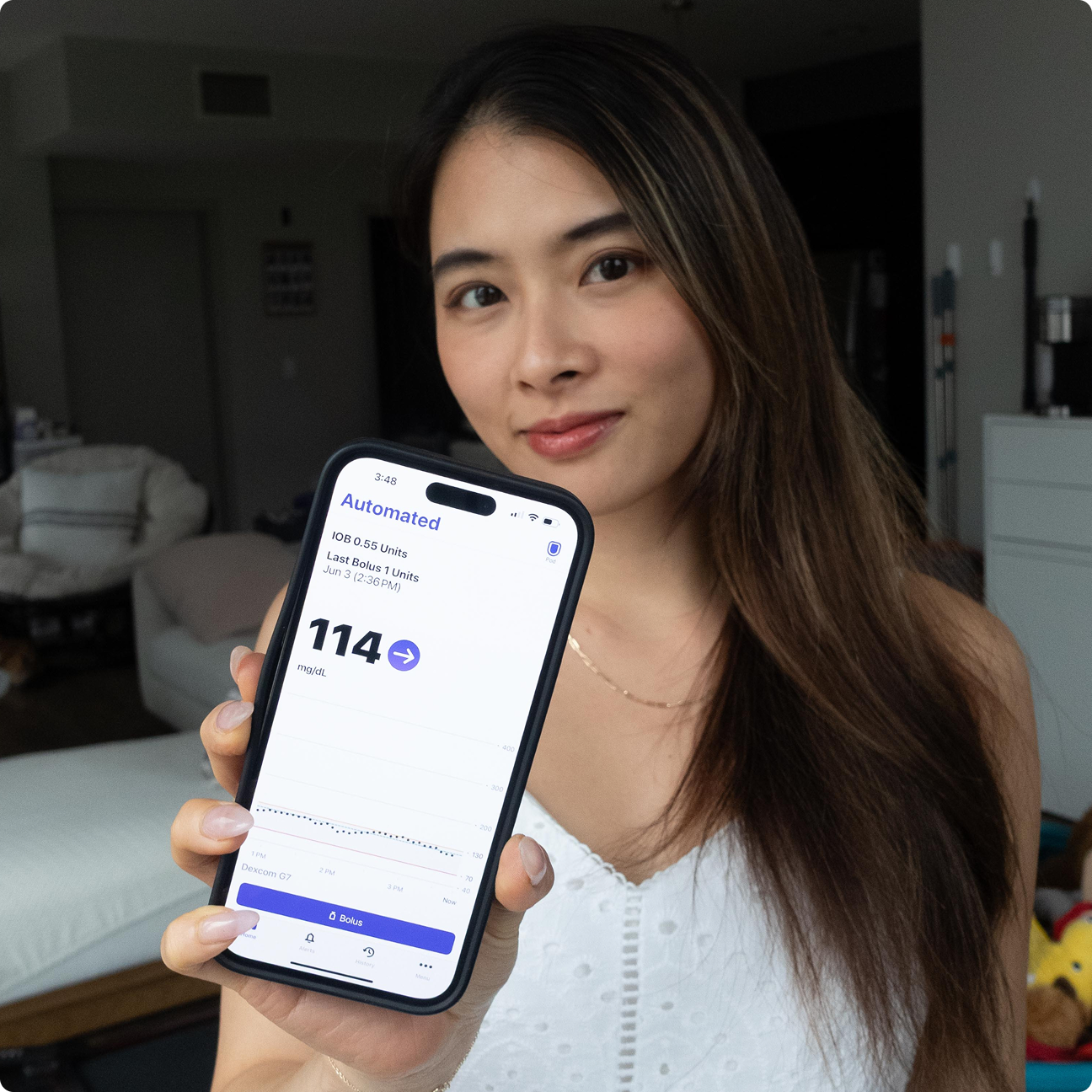 Dexcom Warrior Amy H., smiling showing her Omnipod 5 app on her phone