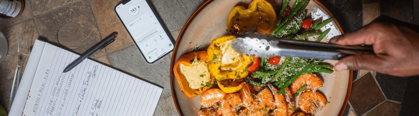 Healthy goals writen on a notepad and a plate of healthy food