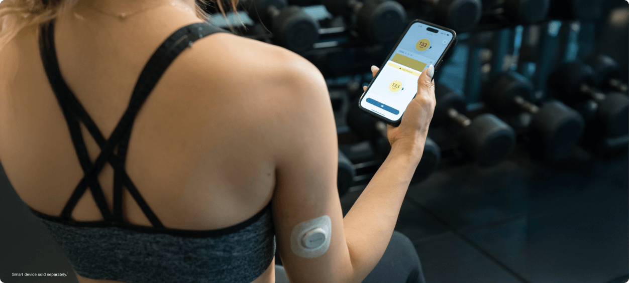 woman checking her glucose readings on a smartpphone - smart devices sold separately