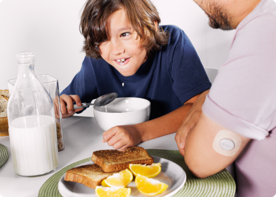 child and parent at a table having breakfast