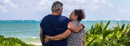 Couple embracing with man wearing the sensor by the beach