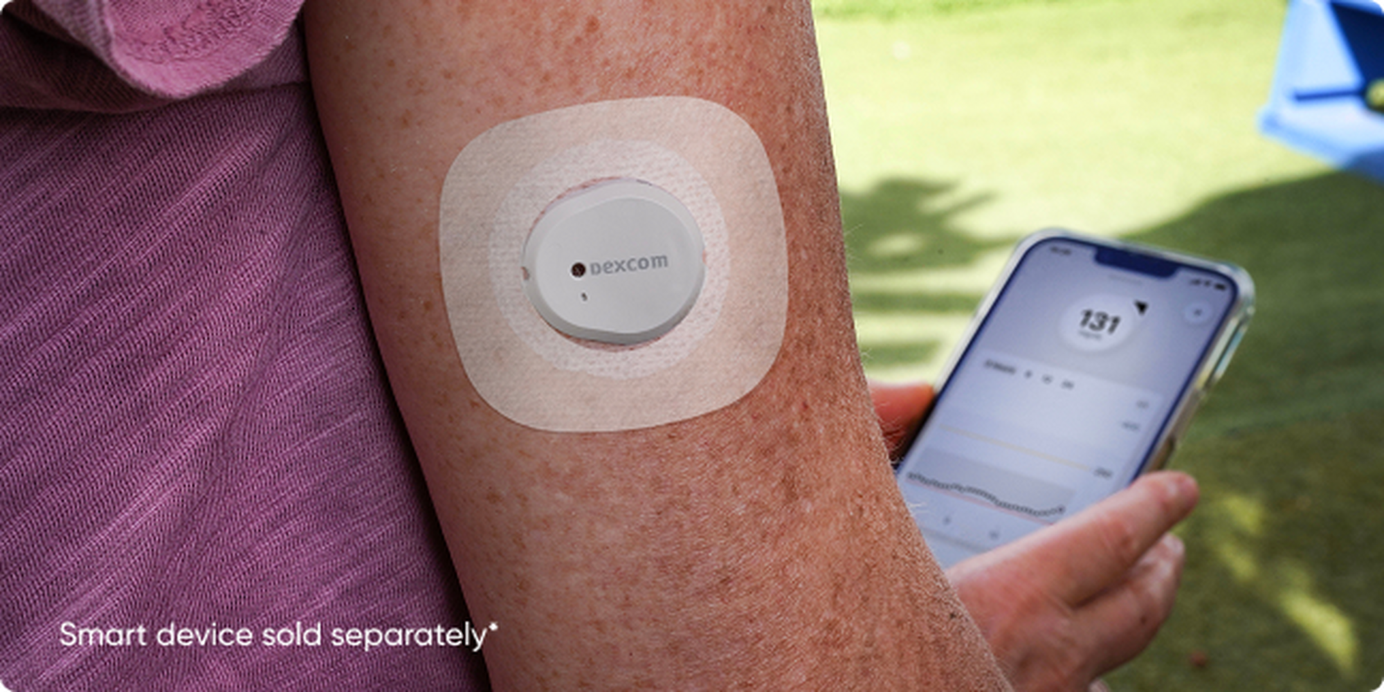 woman checking her readings while wearing the sensor with overpatch on her arm