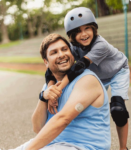 Man wearing the Dexcom G7 with his child wearing rollerblading gear