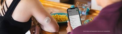 Women sitting and eating while checking event history on Dexcom app