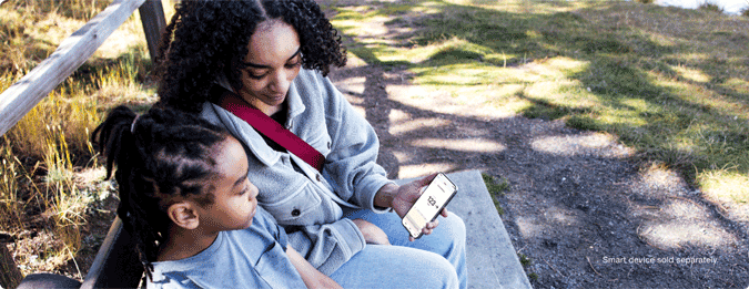 Woman showing her daughter a glucose reading on her smart device