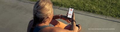 woman checking phone - Smart device sold separately: dexcom.com/compatibility