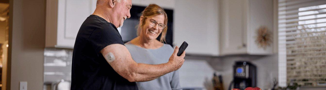 Man wearing sensor showing woman his phone