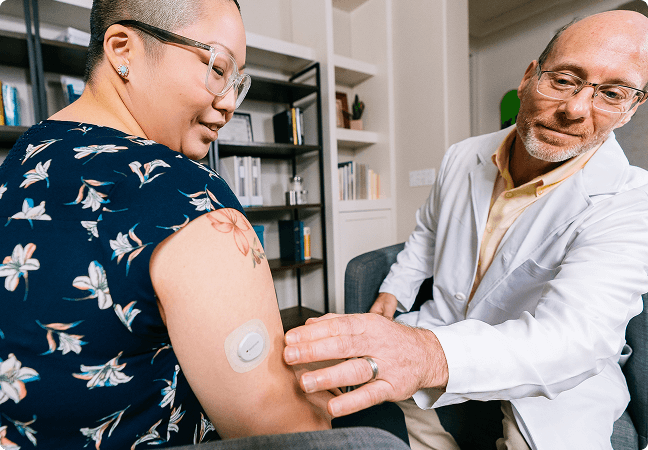 Doctor looking at sensor on womans arm