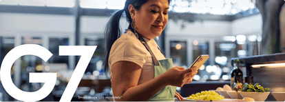 Woman checking her phone while working with food