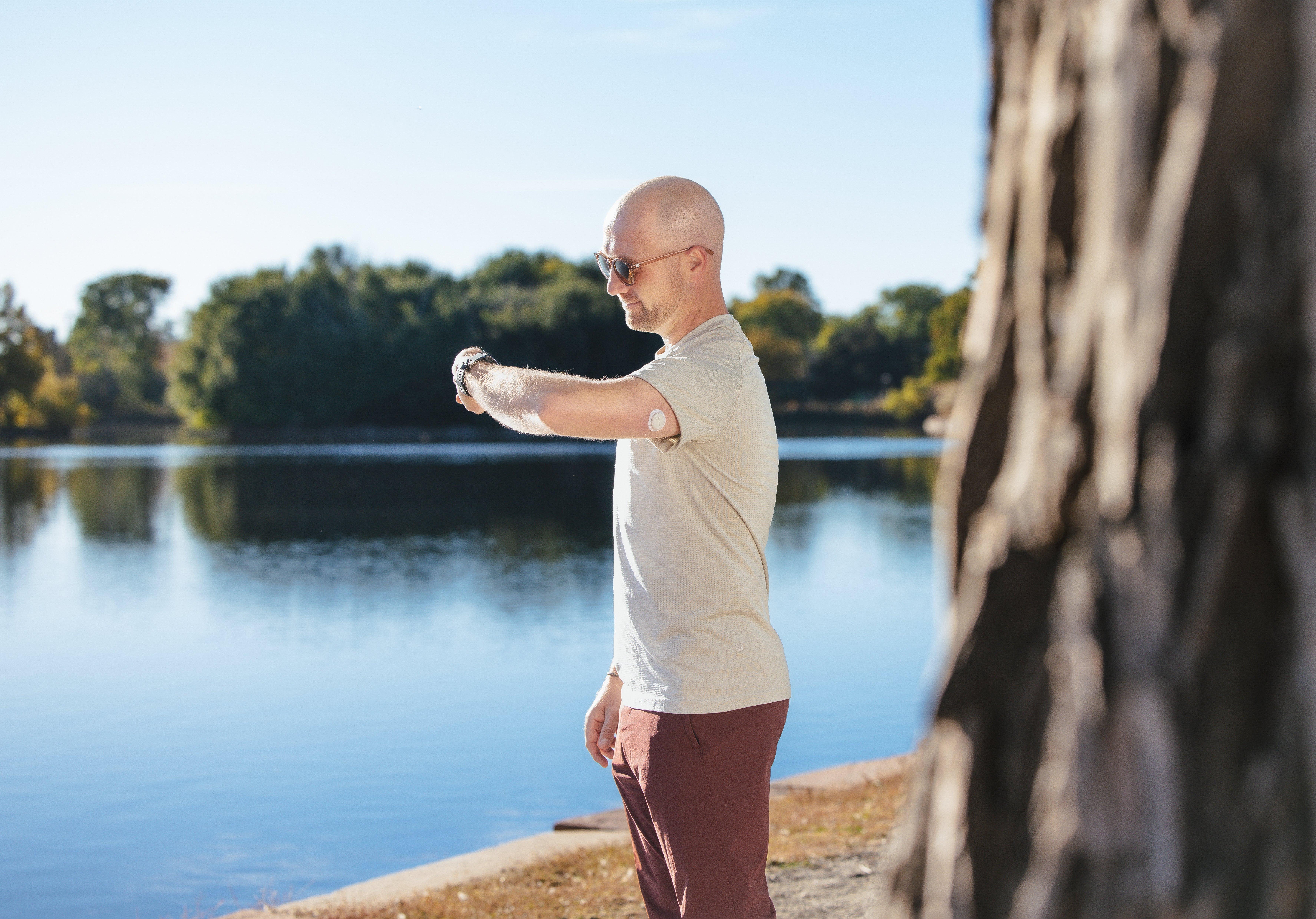 man checking watch by the water wearing the g7 sensor