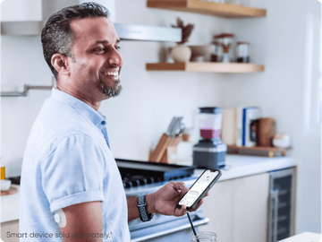 Man checking glucose on his smartphone -  
Smart device sold separately.†