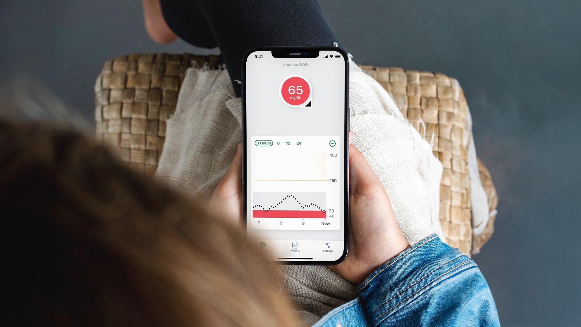 Person holding a receiver with cgm data displayed