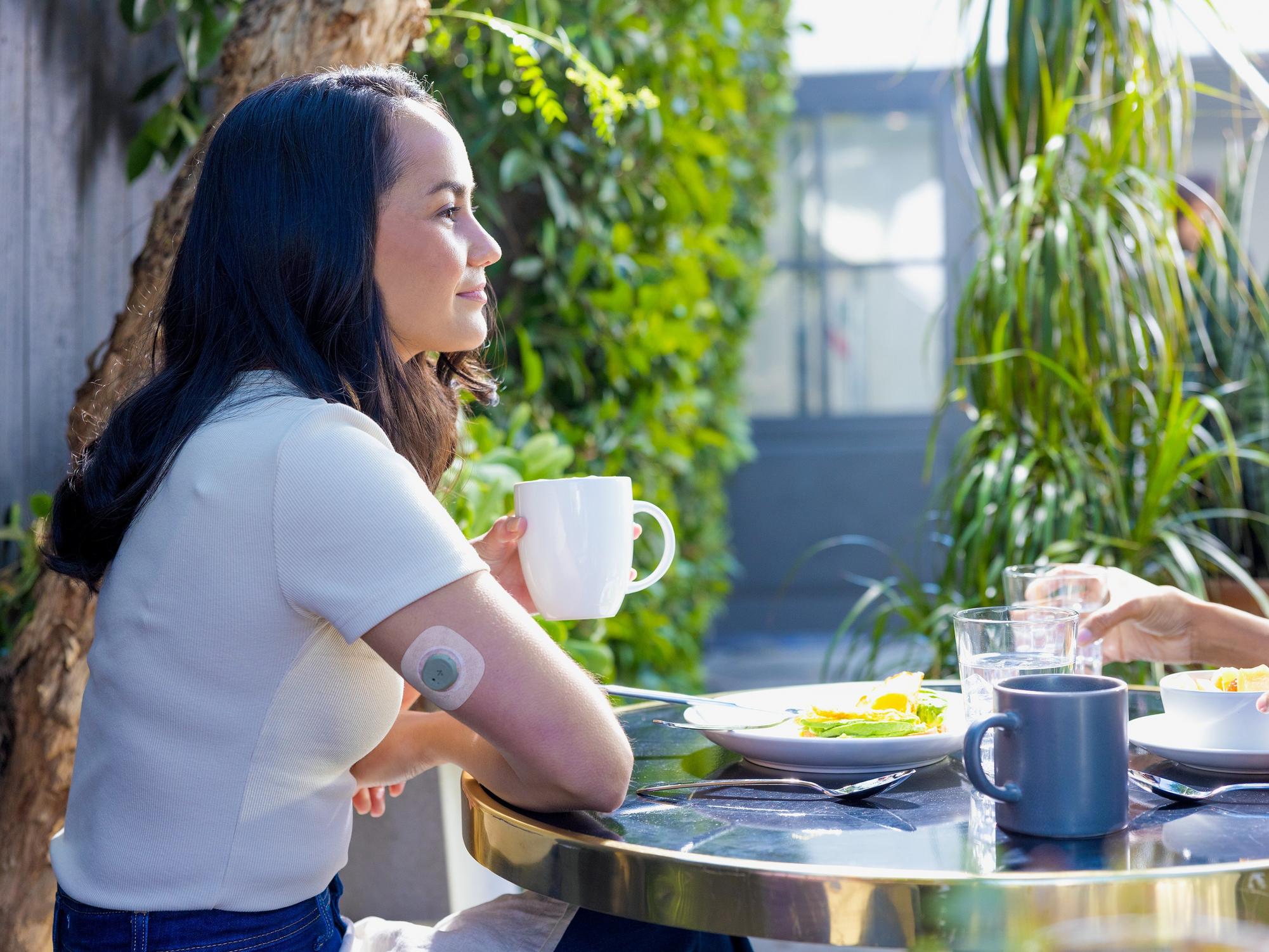 woman drinking coffee wearing Stelo