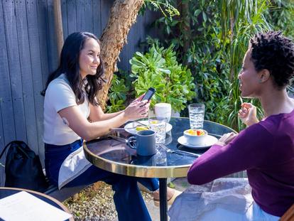 2 Women sitting and eating outside
